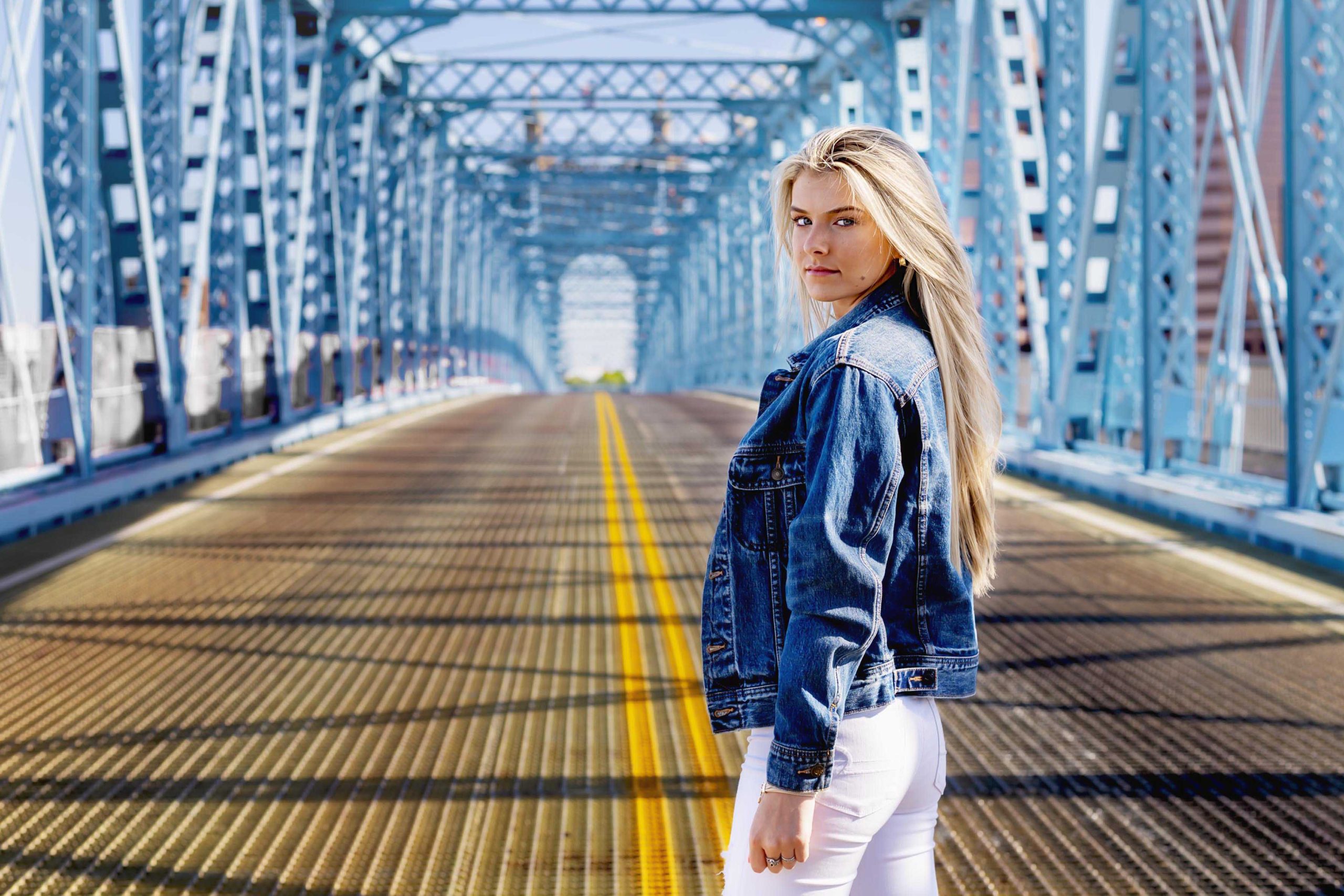 high school senior standing on the Roebling Bridge in Cincinnati for a senior portrait