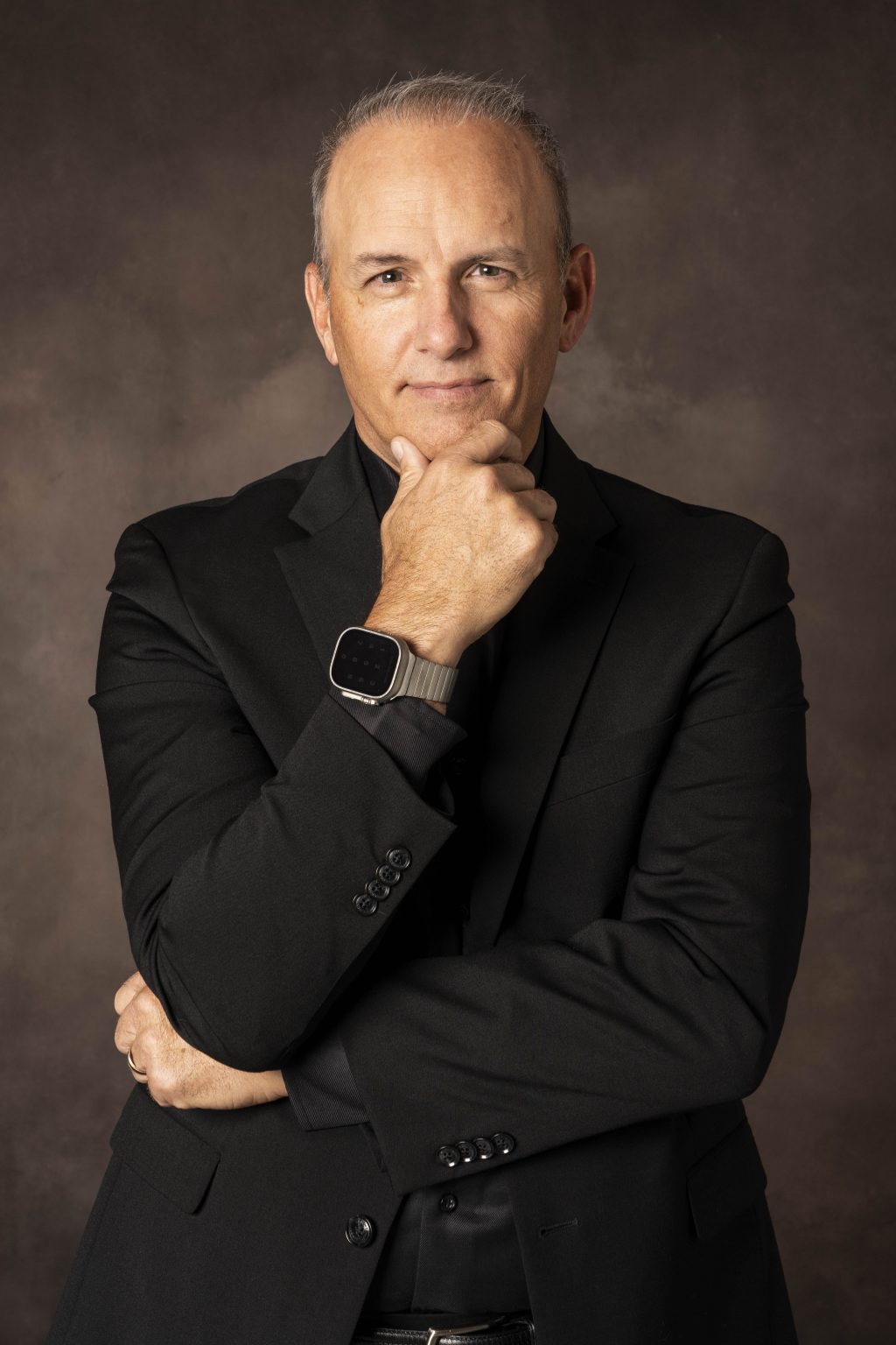 Business headshot of a man in studio in a black suit made by tonya bolton photography.