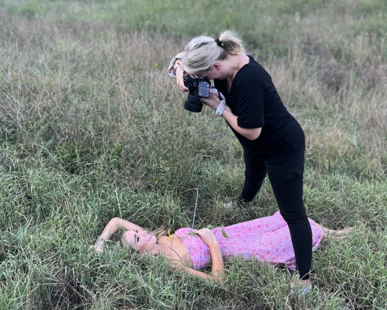 Behind the scenes photo of Cincinnati photographer, tonya bolton, standing over her client with her camera in Eden Park.